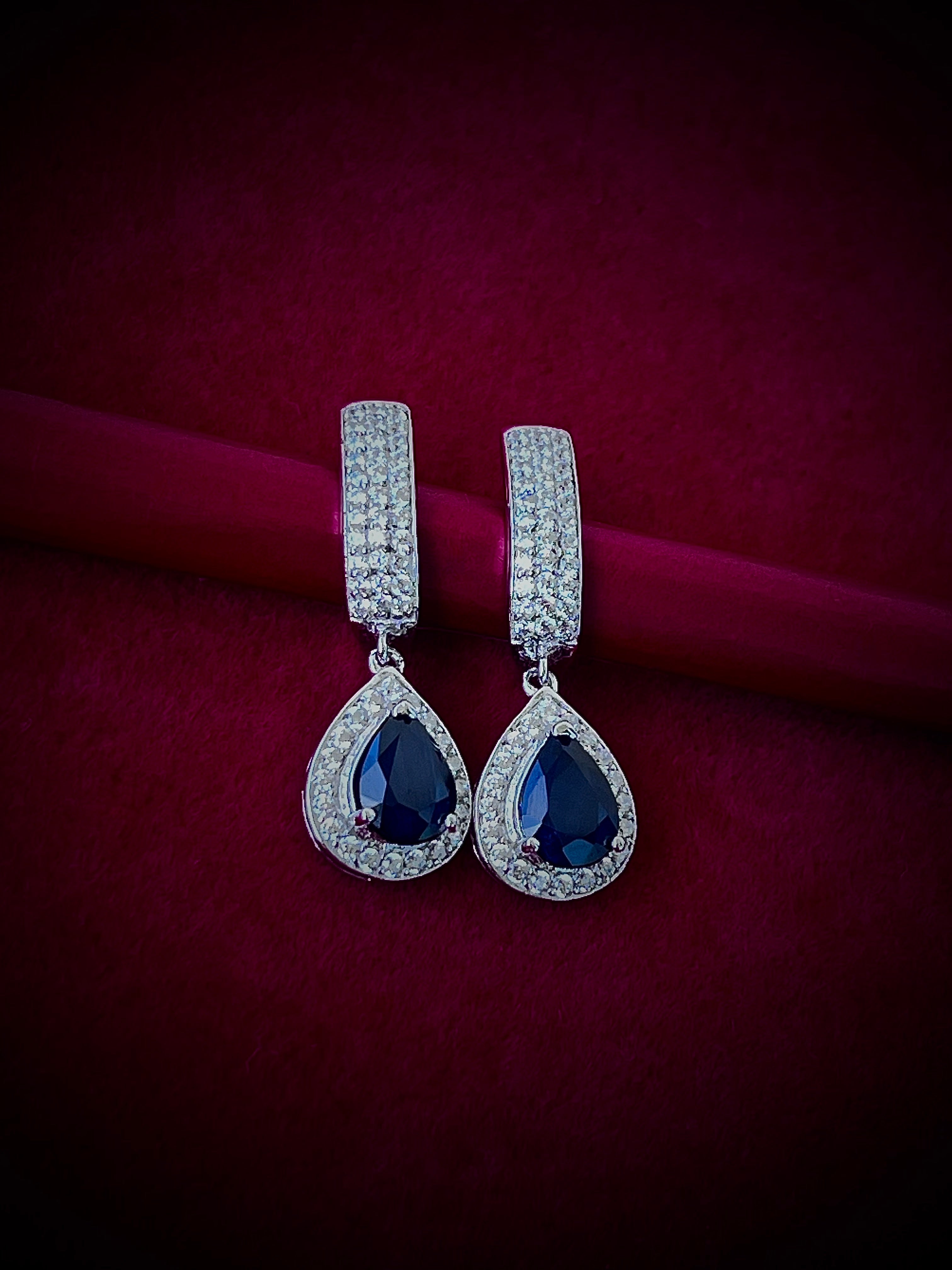 Haspiera blue sapphire drop earrings with teardrop gemstones surrounded by small diamonds