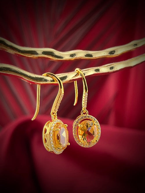 Haspiera citrine yellow hook earrings with gold setting and intricate design on red background