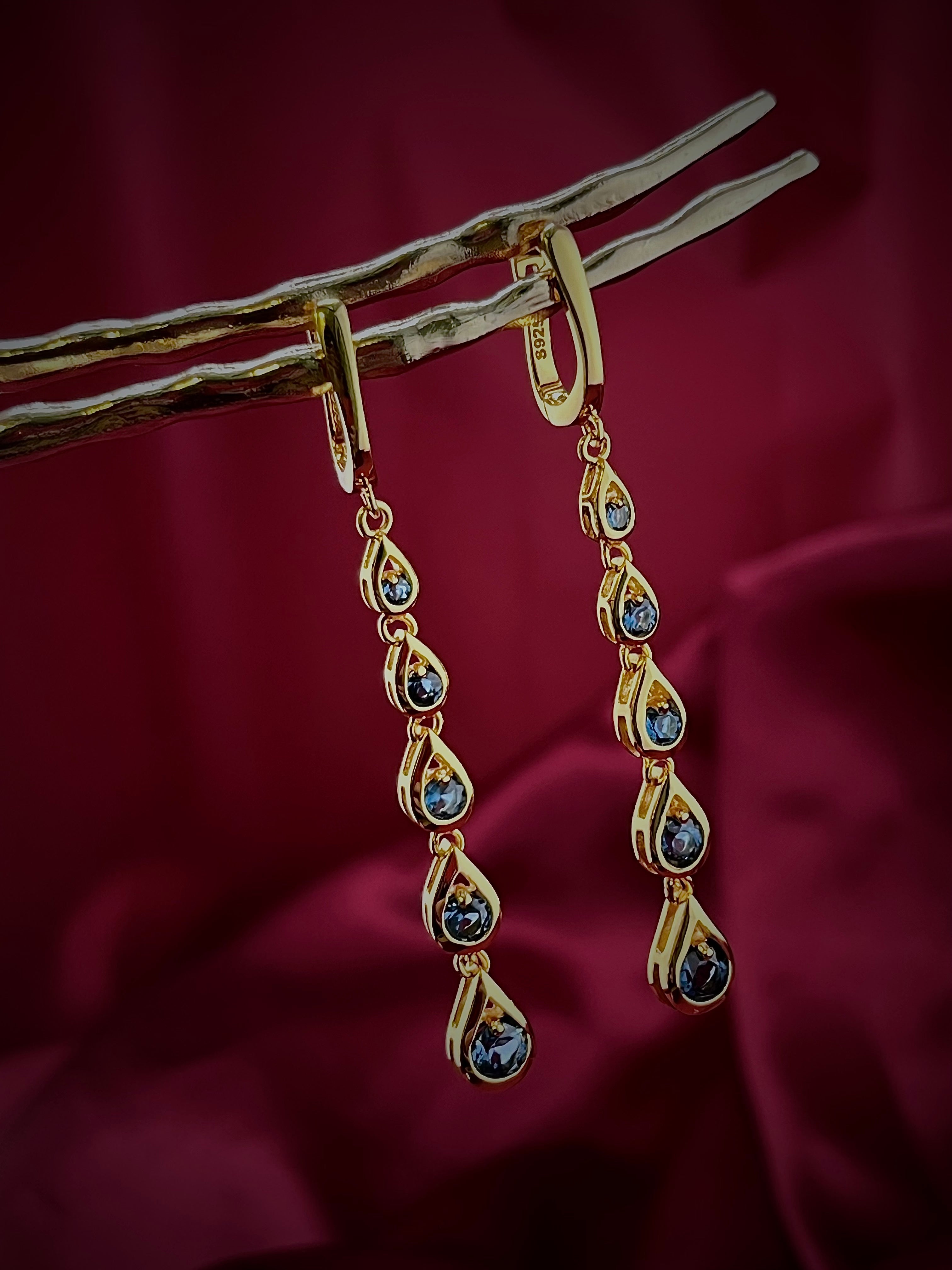 Haspiera blue cocktail dangle earrings featuring gold setting with multiple teardrop blue stones