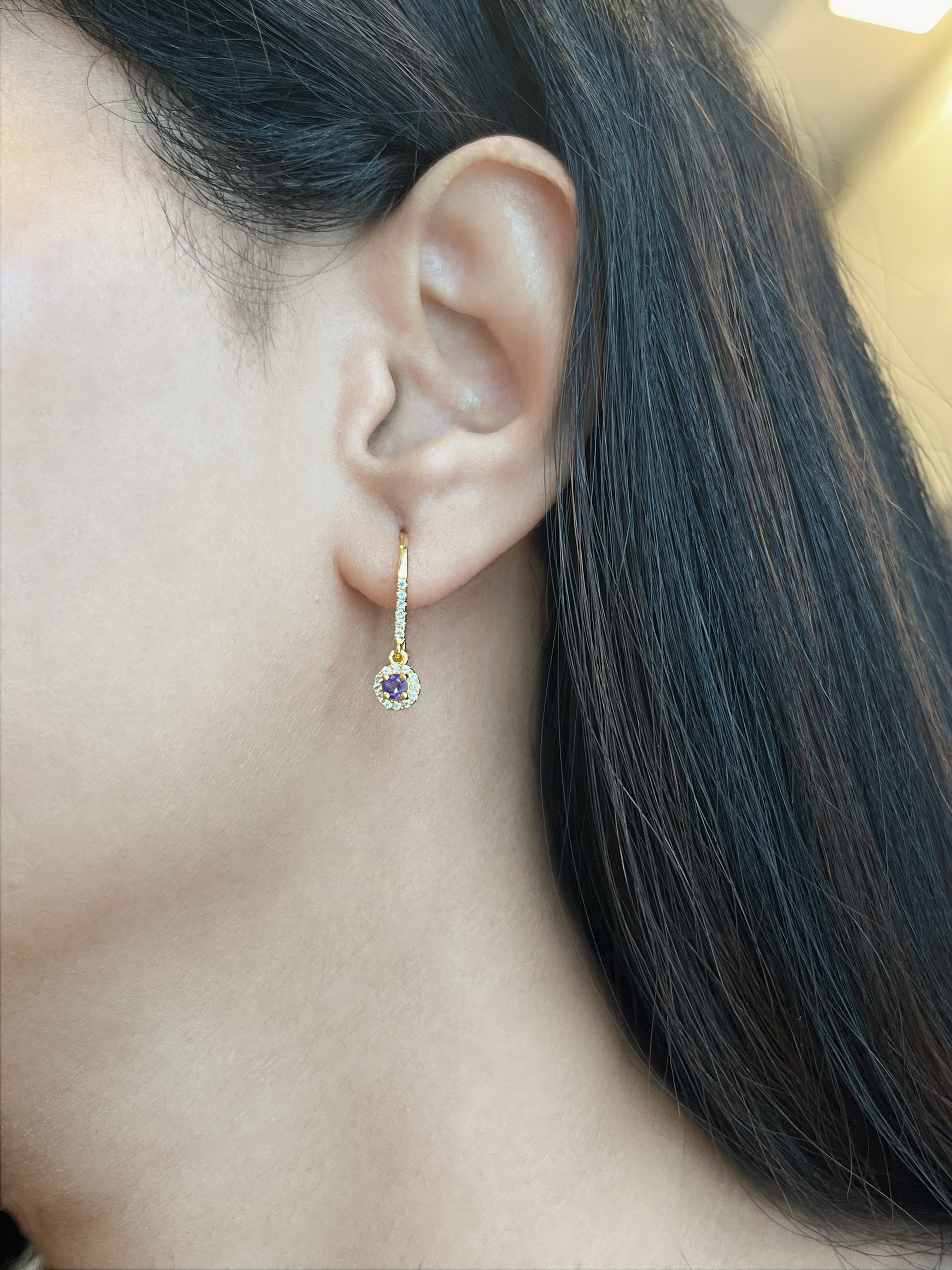 Haspiera violet drop earrings with gold setting and purple gemstone worn on ear