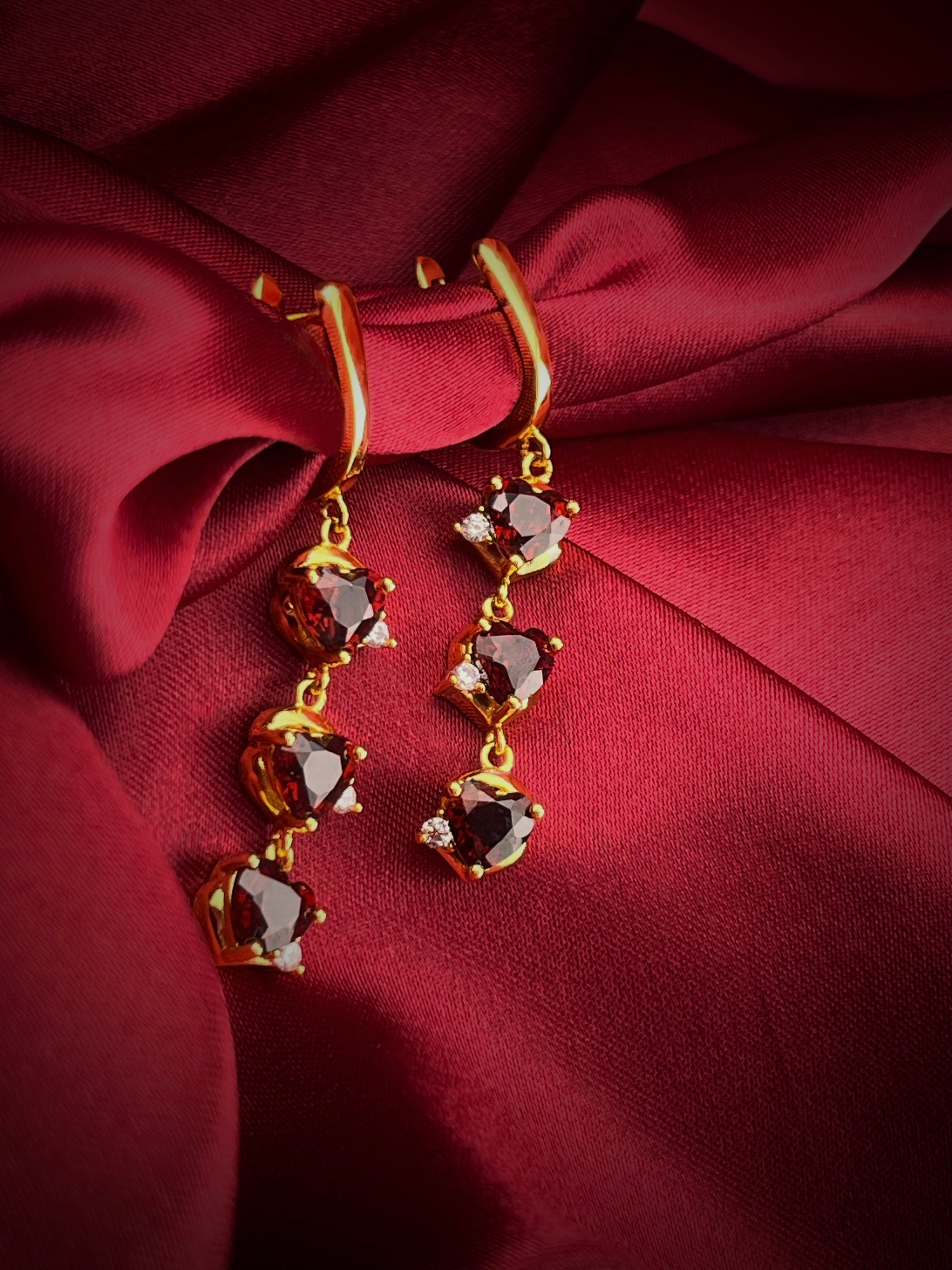 Haspiera demi-fine gemstone earrings for women with red stones and gold setting on red fabric