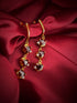 Haspiera demi-fine gemstone earrings for women with red stones and gold setting on red fabric