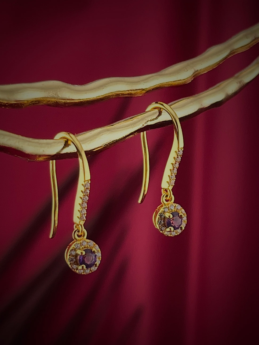 Haspiera gold violet drop earrings with gemstone and small diamonds on elegant display