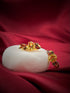 Haspiera harvest hues earrings featuring yellow and red gemstones set in gold on a white display with red fabric background