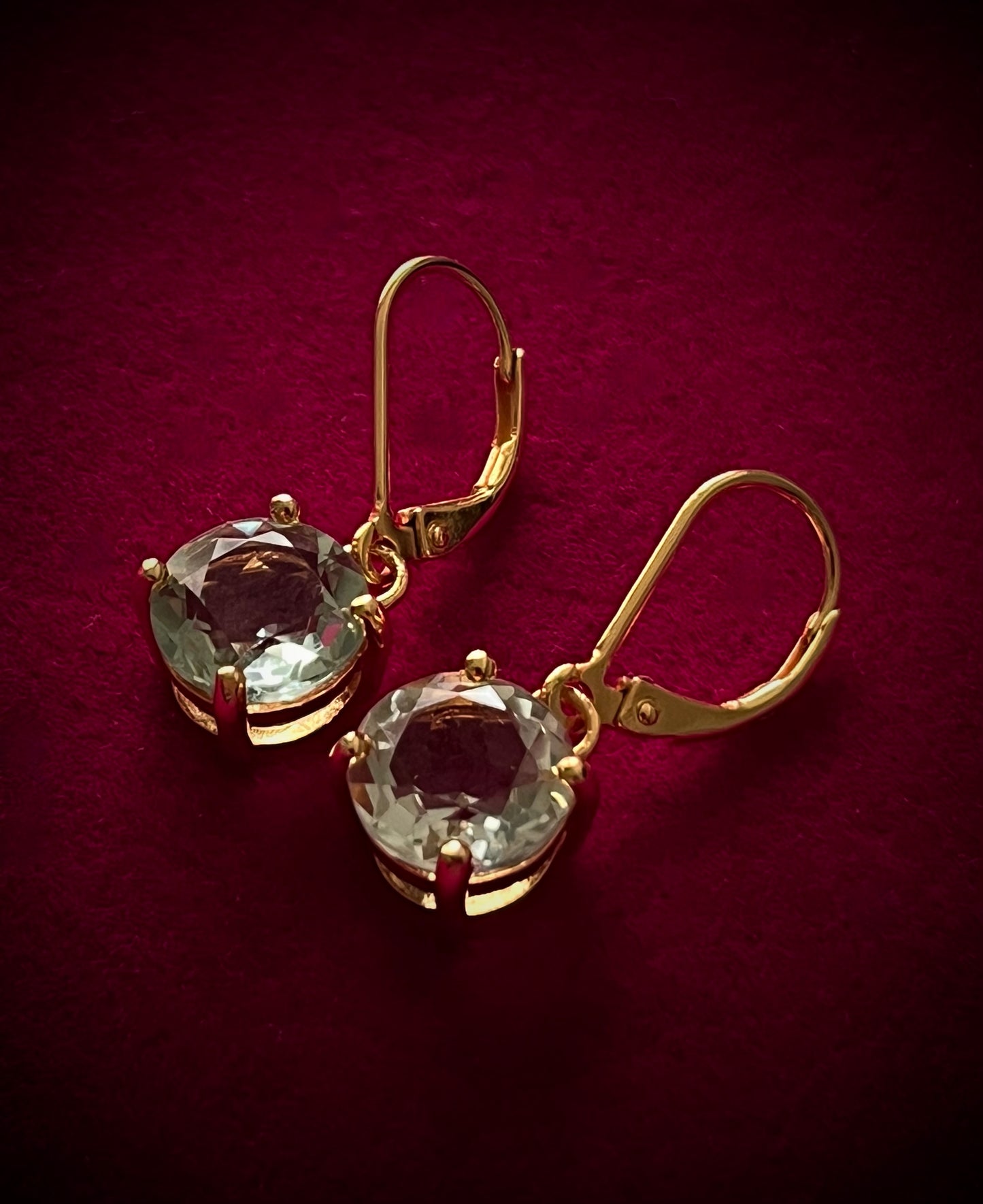 Kate's Love green amethyst drop earrings by Haspiera with gold setting on dark red background
