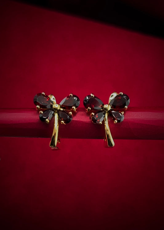 Haspiera red butterfly earrings with gemstone petals and gold-tone stems on red background