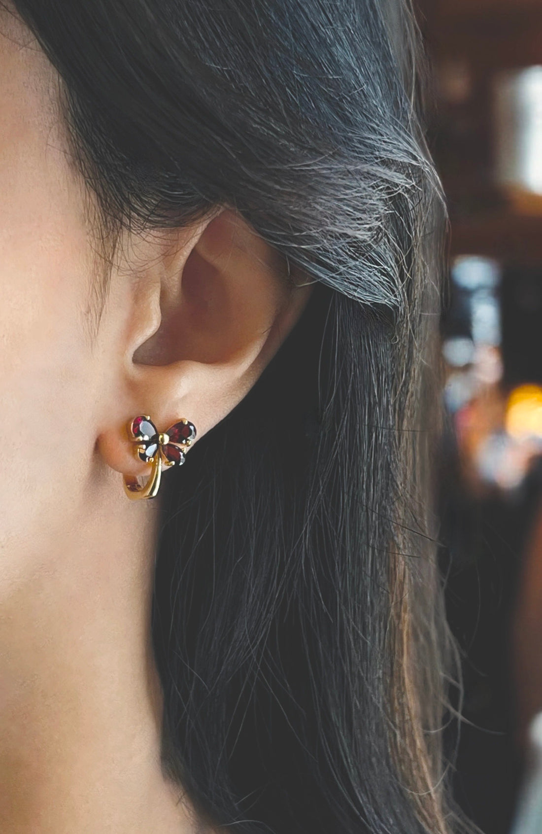 Haspiera red butterfly earrings with gemstone details worn on ear for elegant style