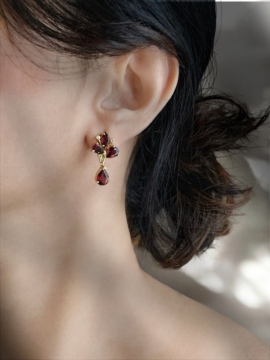 Haspiera red trillium drop earrings featuring deep red gemstones in gold setting worn on ear