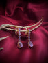 Haspiera royal lilac dangle earrings featuring multiple lilac gemstones set in gold on a red fabric background